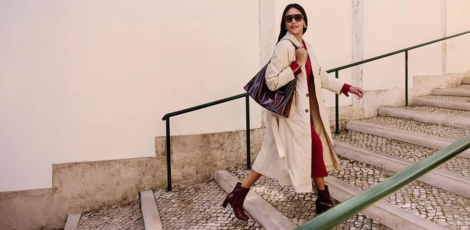 Trench elegante, accenti rossi, stivali appariscenti. Combinazione elegante per un look urbano.