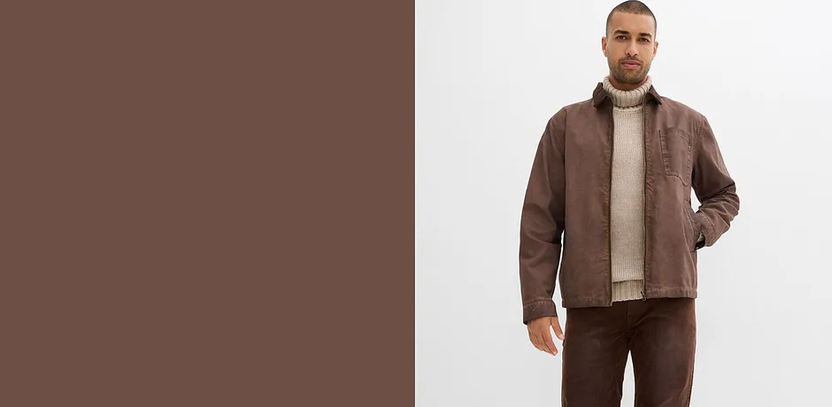Giacca di pelle marrone, maglione a collo alto beige e pantaloni abbinati.