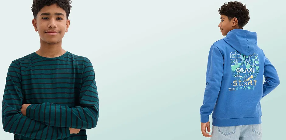 Una maglia a righe verde e nera con maniche lunghe e una felpa blu con cappuccio con una stampa colorata dello spazio sul retro.