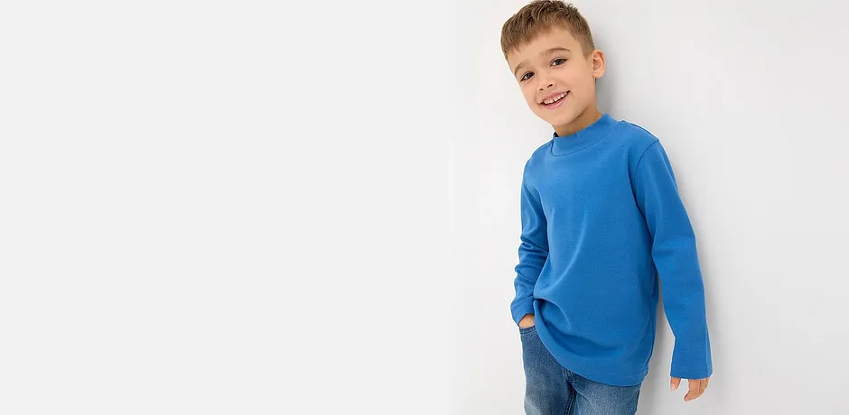 Maglione blu a maniche lunghe e classici jeans blu.