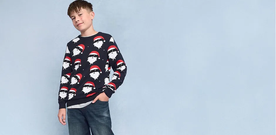 Maglione con motivi natalizi abbinato a jeans casual. 