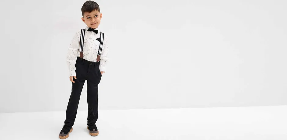 Un bambino indossa una camicia e un papillon.