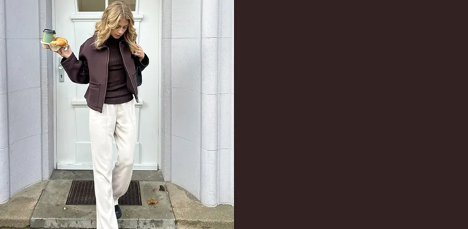 Look casual con giacca scura e pantaloni chiari.