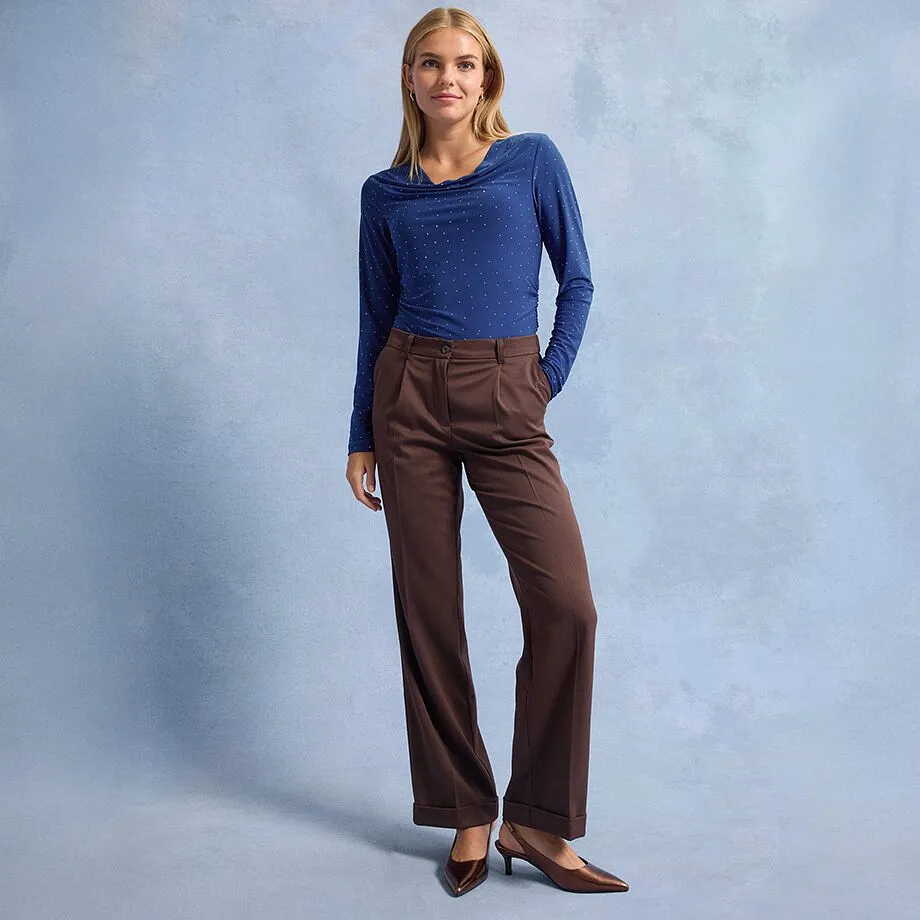 Maglia blu a maniche lunghe con pois, pantaloni marroni a gamba larga e scarpe marroni a punta.