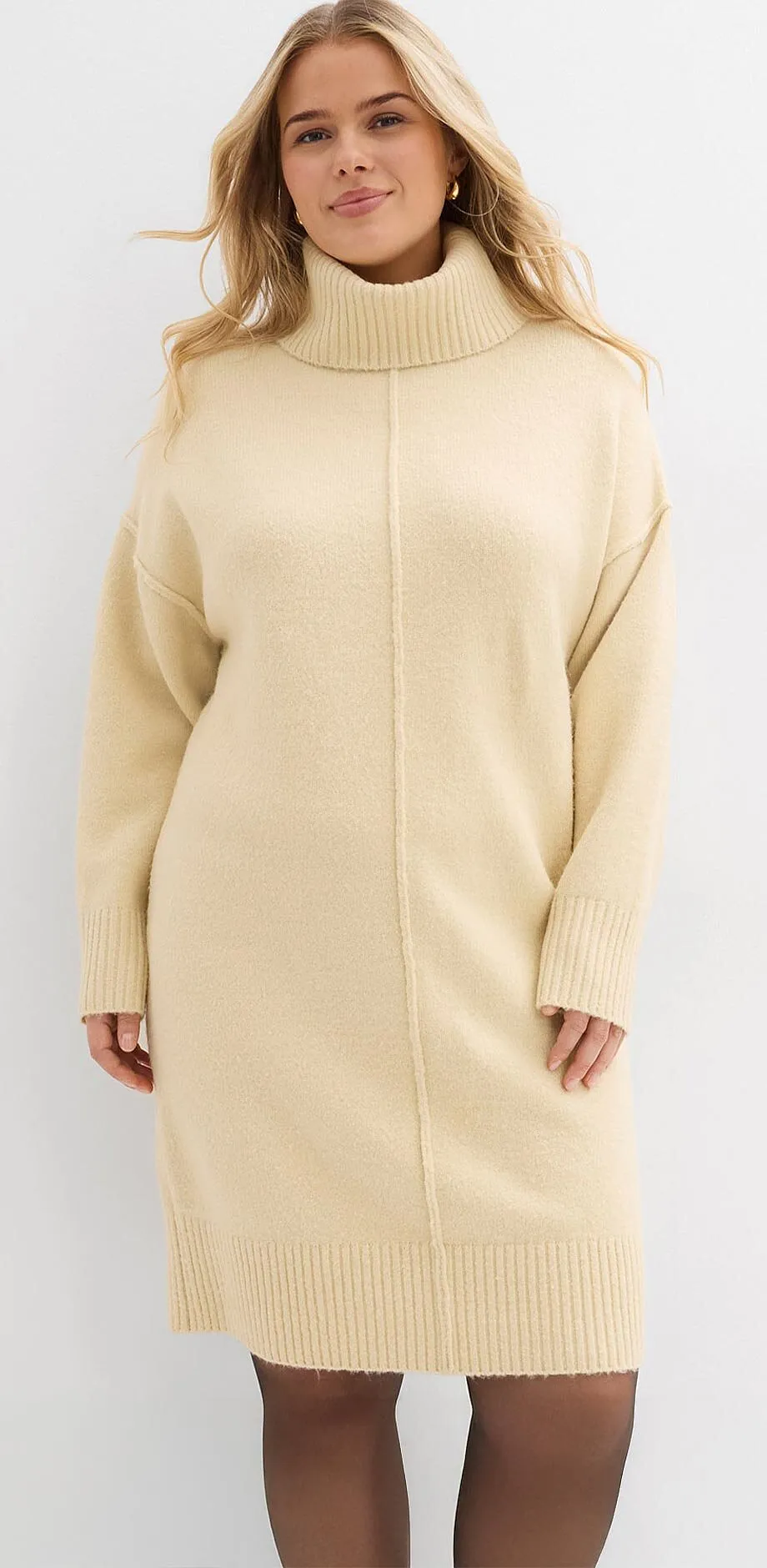 Abito in maglia bianco crema con collo alto e maniche lunghe.