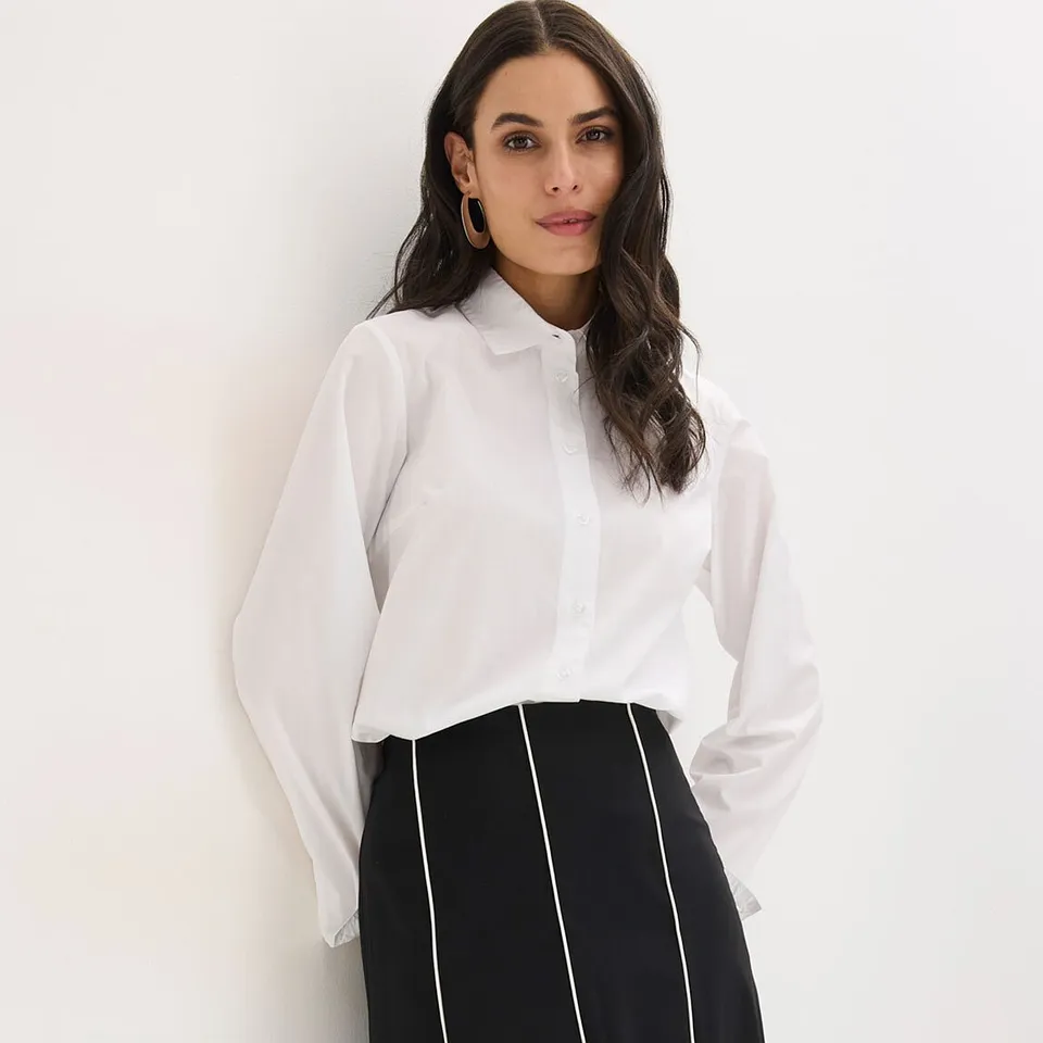 Camicetta bianca con colletto e gonna bianca e nera a righe verticali.