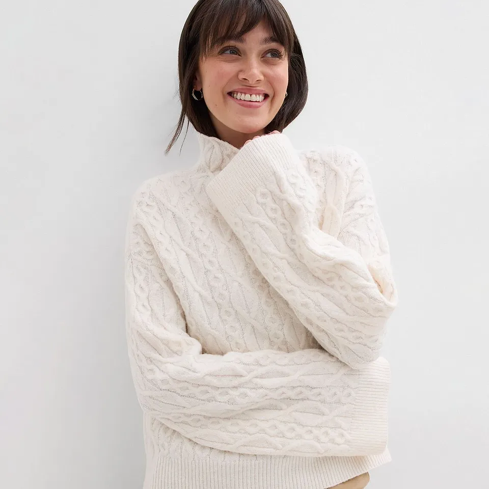 Maglione bianco lavorato a maglia con collo alto e motivo strutturato.