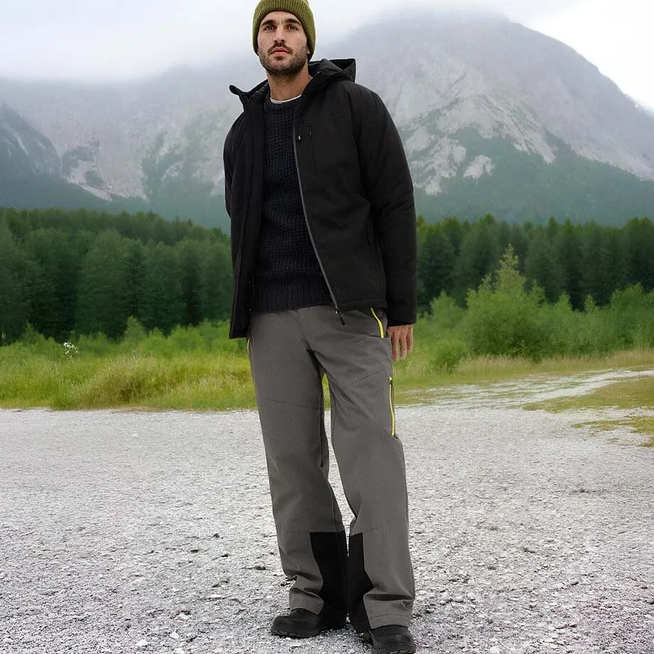 Giacca invernale scura, pantaloni grigi e berretto verde.