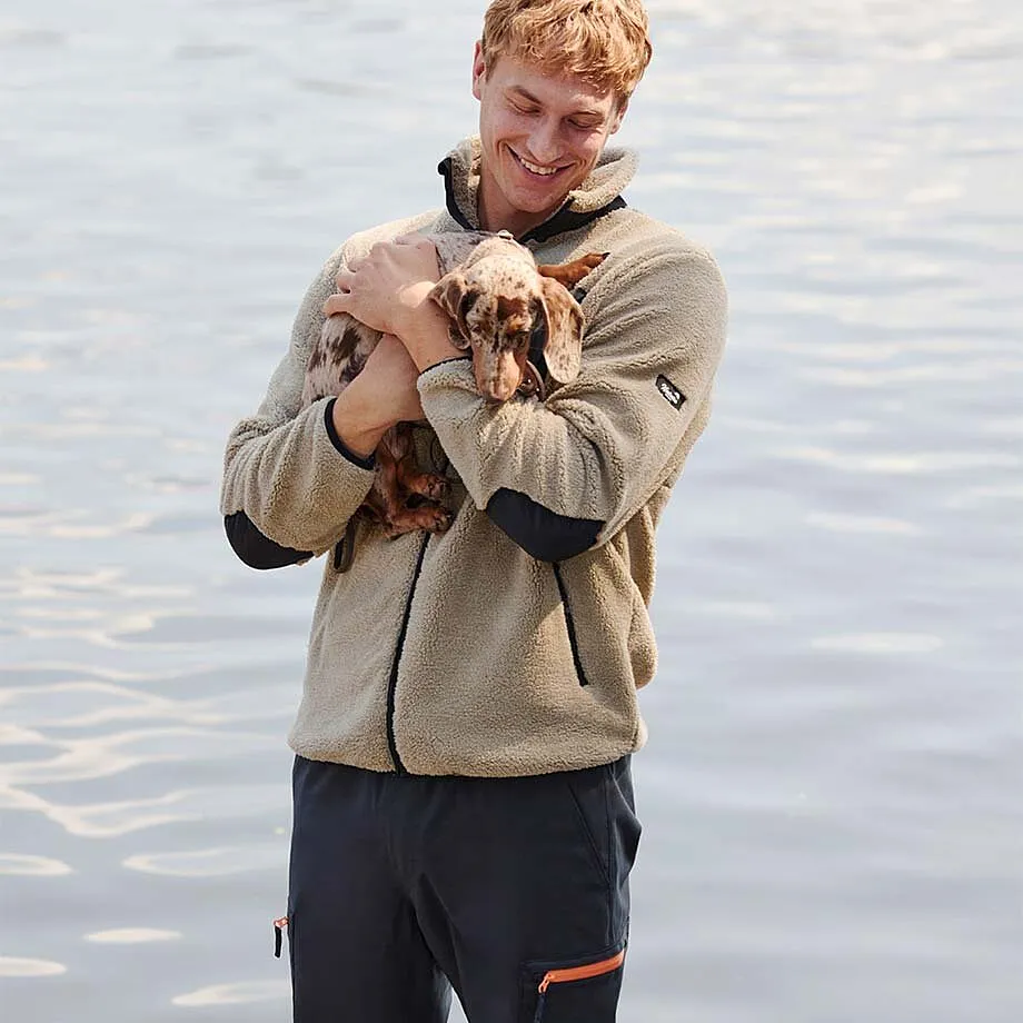 Giacca in pile beige abbinata a pantaloni scuri.