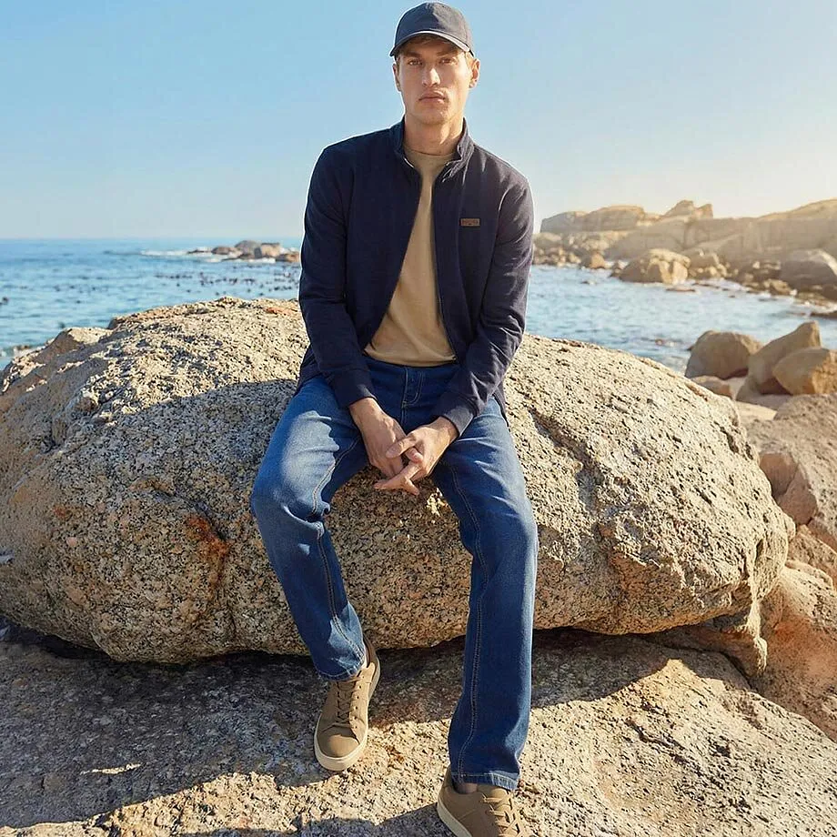 Giacca blu, camicia beige e jeans per le giornate di sole al mare.