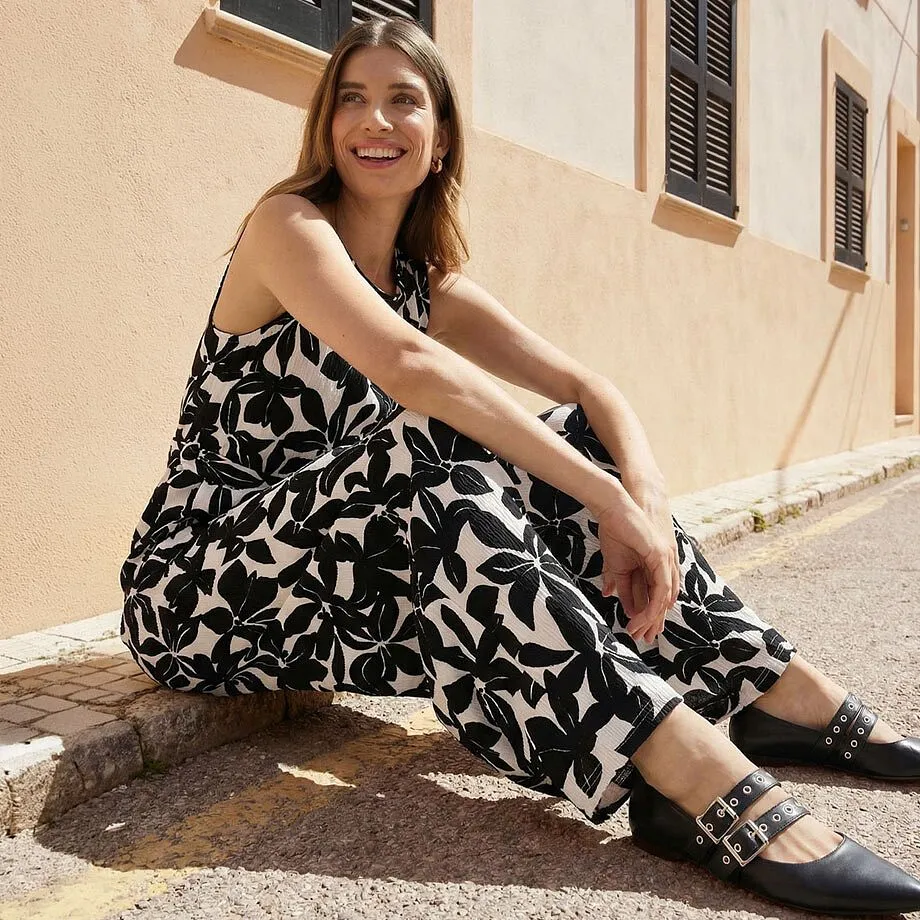 Tuta con motivo floreale bianco e nero e senza maniche.