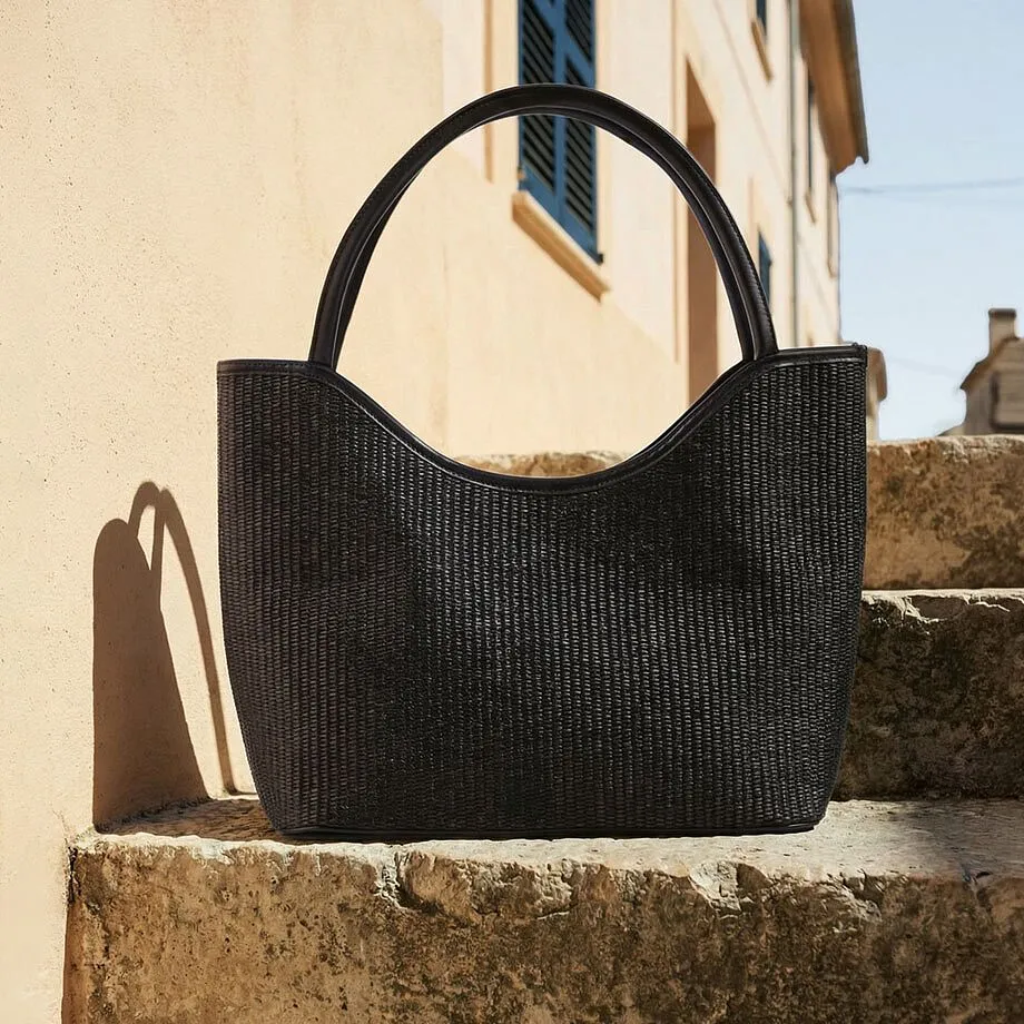 Borsa nera in materiale intrecciato.