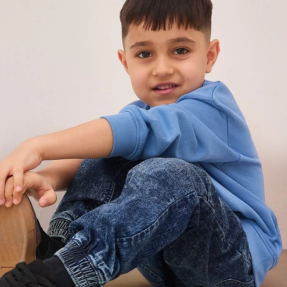 Un maglione blu e dei jeans creano un look casual per i pi&ugrave; piccoli.