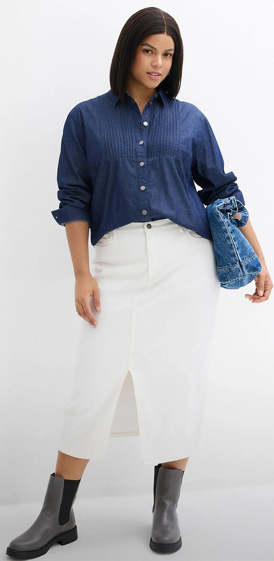 Camicia blu abbinata a una gonna bianca. 