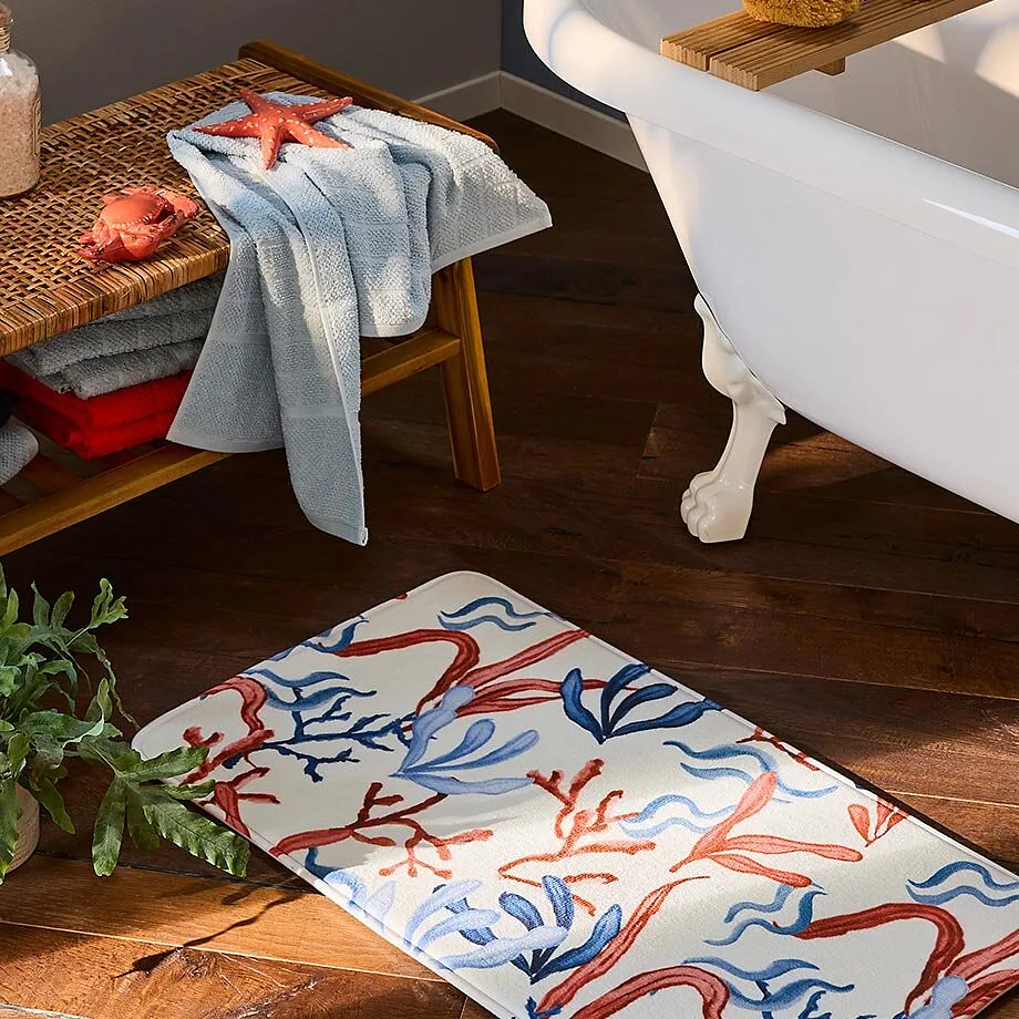 Un asciugamano azzurro &egrave; appoggiato su una panca di legno accanto a una vasca da bagno.