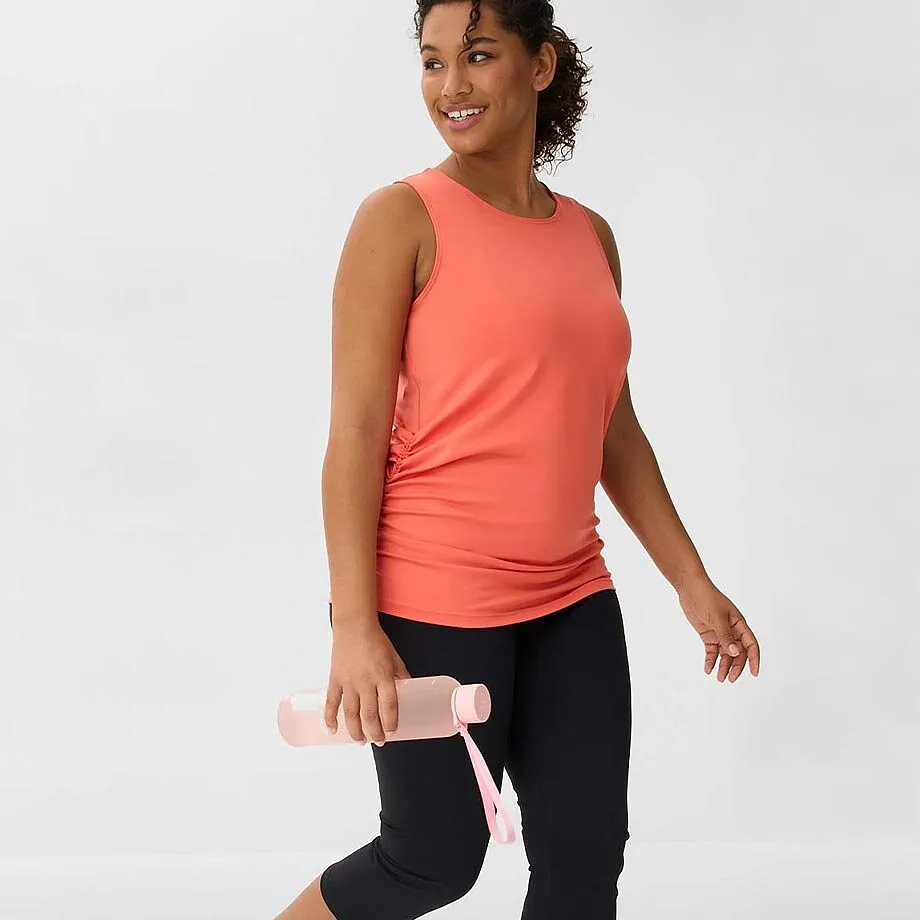 Outfit sportivo con canotta color corallo e pantaloni capri neri.