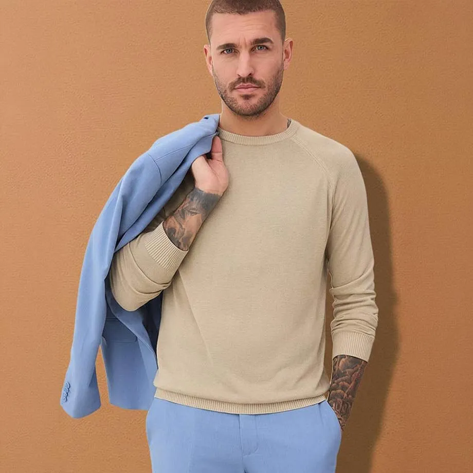 Maglione chiaro, giacca azzurra e pantaloni abbinati. 