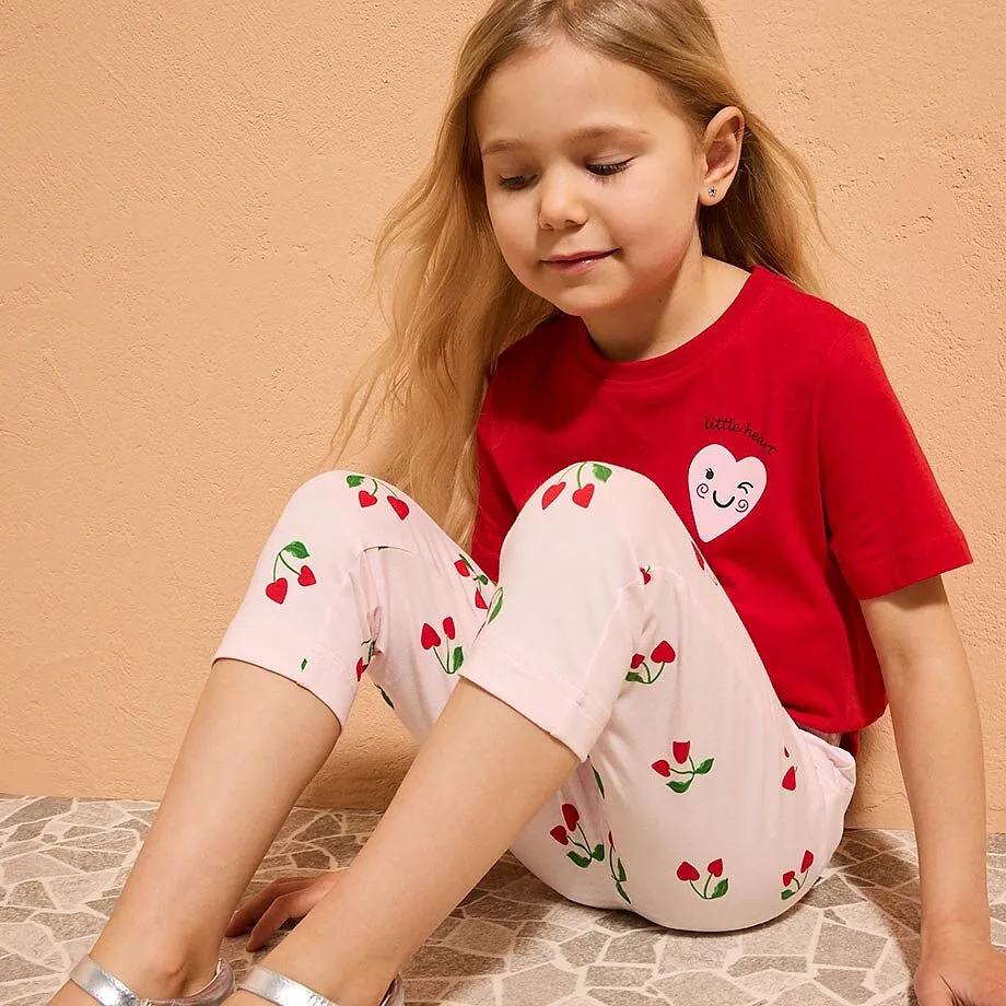 Una bambina indossa una maglietta rossa con un motivo a cuori.