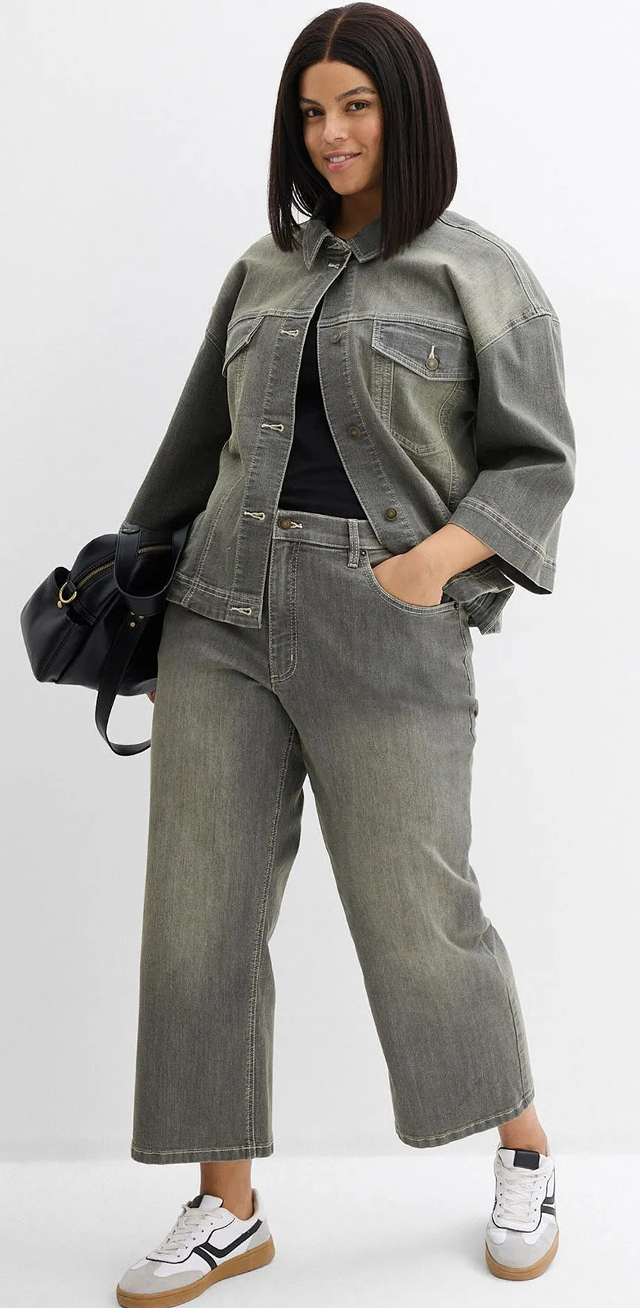 Giacca di jeans grigia abbinata a jeans larghi.