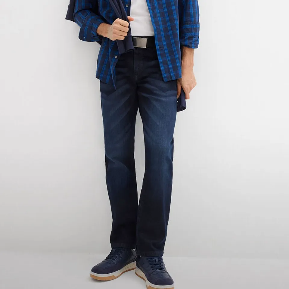 Camicia a quadri, jeans scuri e scarpe abbinate color blu navy.