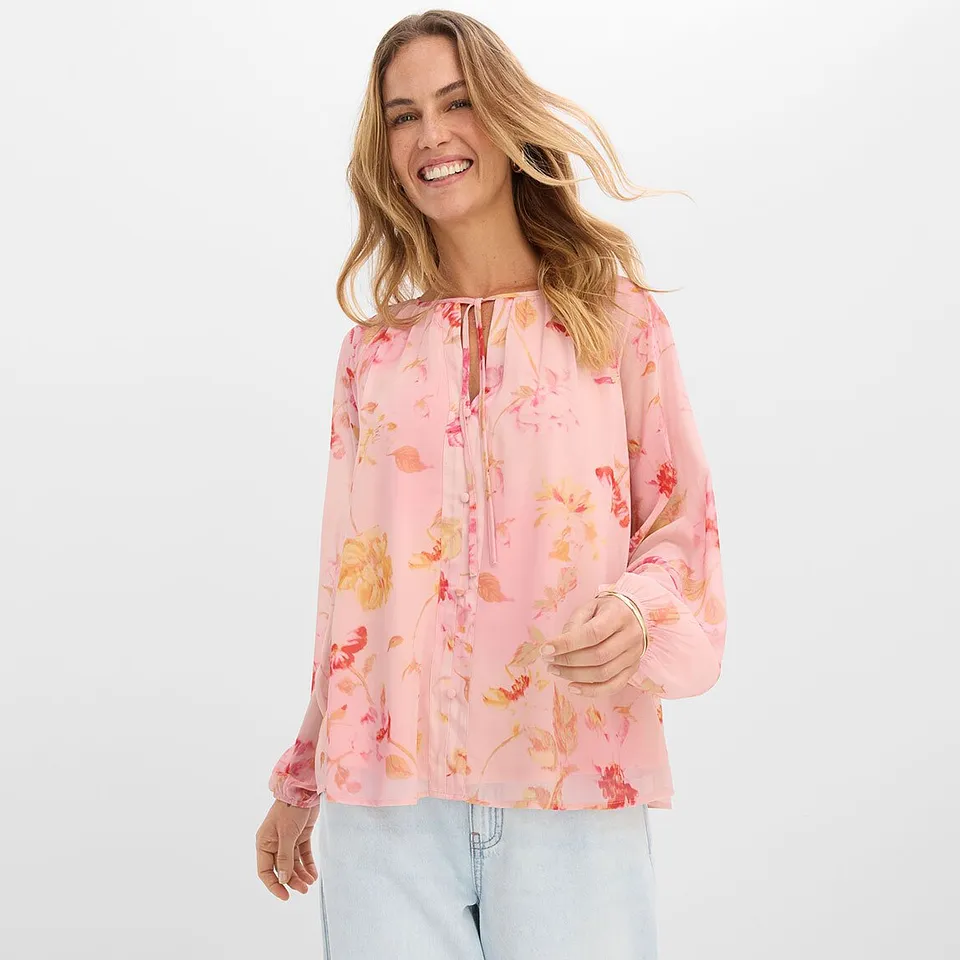 Blusa rosa a fiori e jeans chiari.