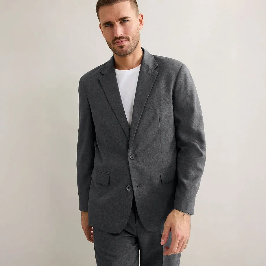 Elegante abito grigio con una semplice maglietta bianca sotto. 