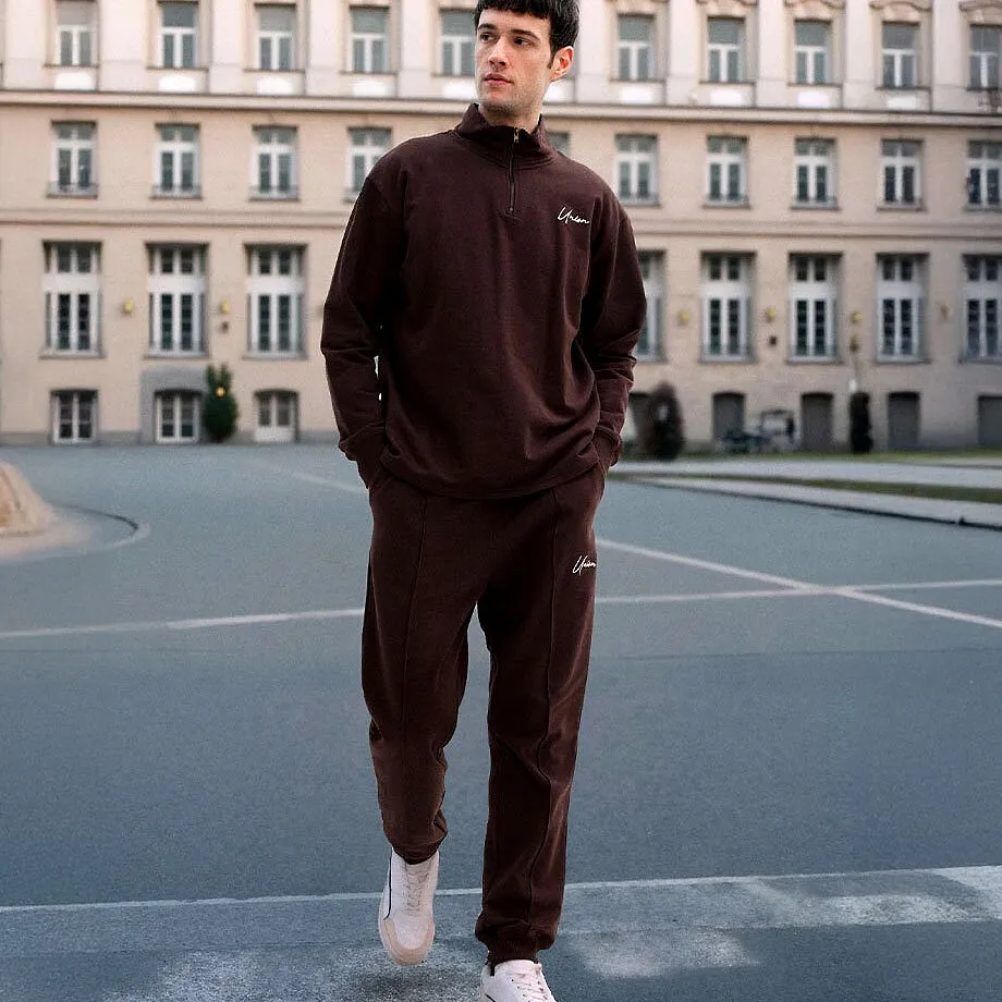 Tuta da ginnastica marrone scuro, scarpe da ginnastica bianche.