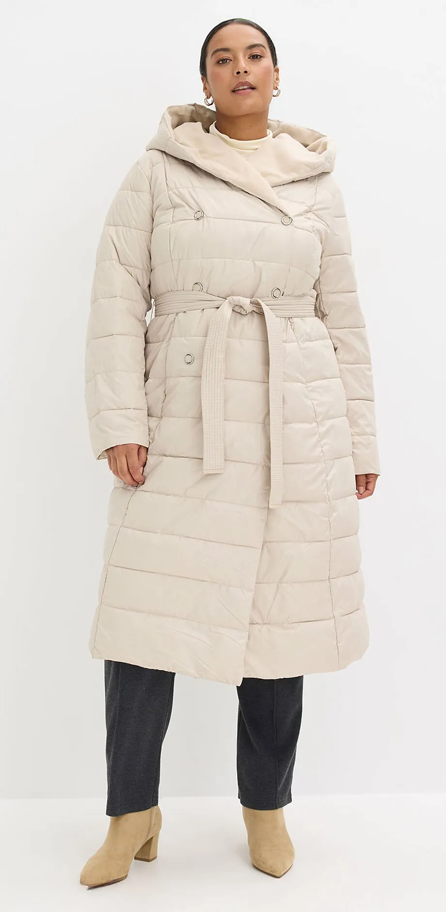 Cappotto trapuntato color crema con cappuccio e cintura.
