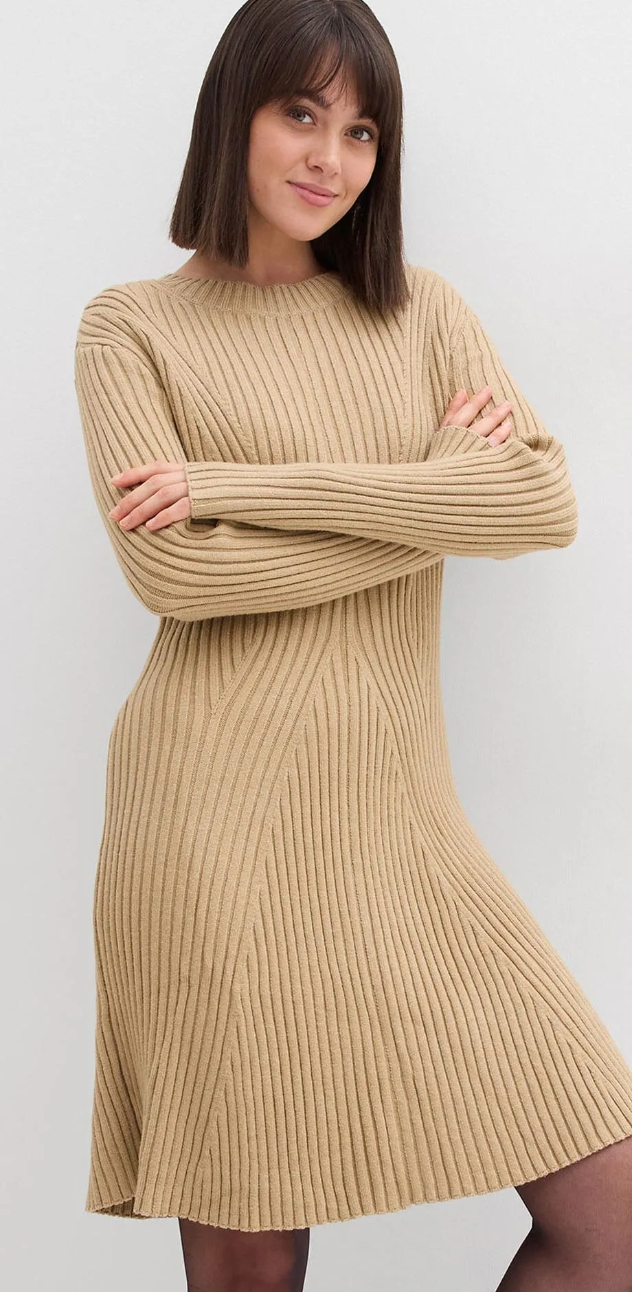 Abito beige in maglia con motivo a coste, maniche lunghe e gonna leggermente svasata.