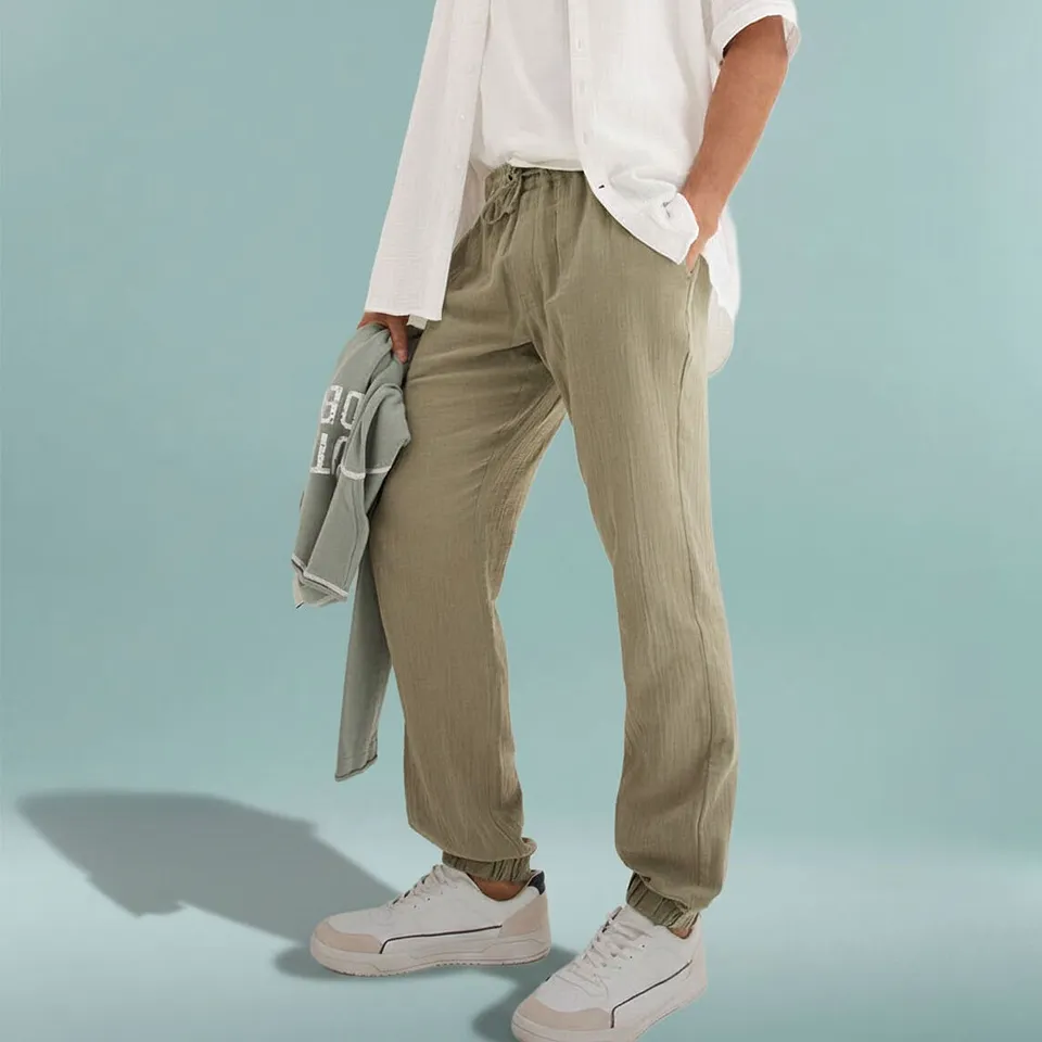 Pantaloni comodi verde oliva con t-shirt bianca e camicia bianca.