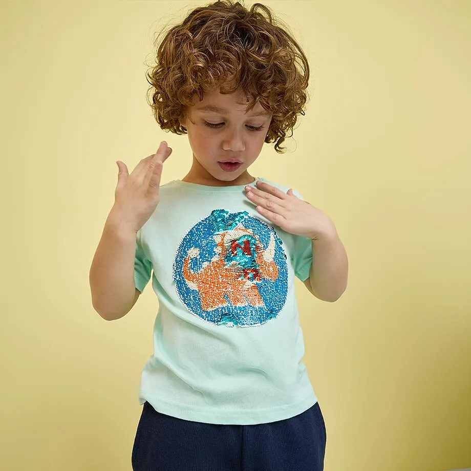 Un bambino indossa una maglietta turchese con una stampa colorata.