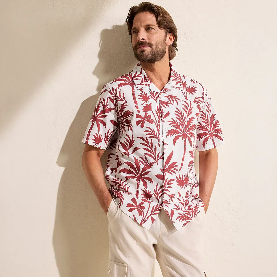Camicia casual in fantasia a maniche corte e pantaloni beige.
