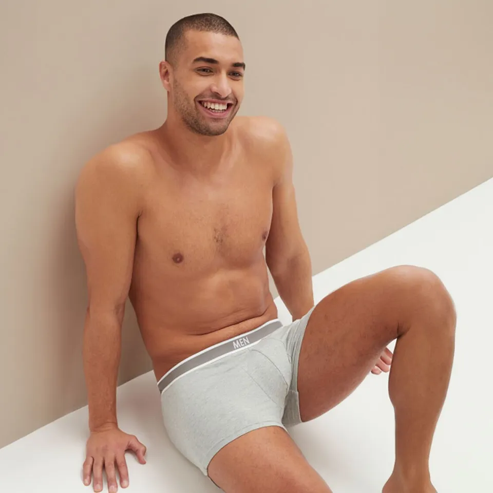Un uomo indossa dei boxer grigi con elastico in vita.