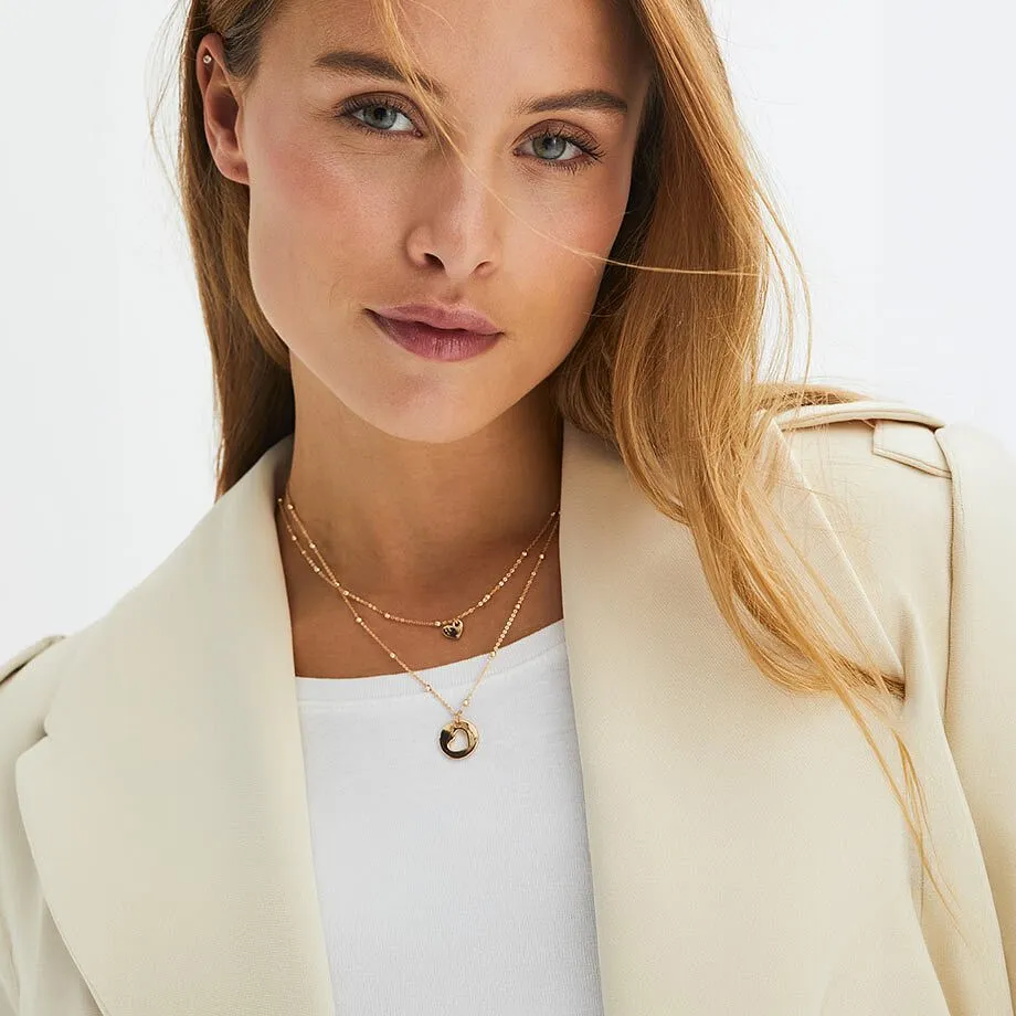 Una donna indossa un blazer beige chiaro con una collana.