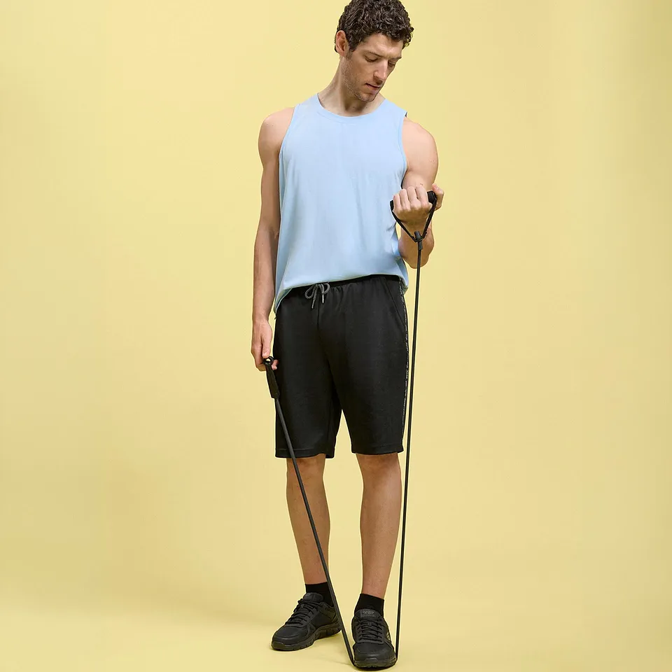 Una canottiera azzurra, pantaloncini neri e scarpe da ginnastica scure.