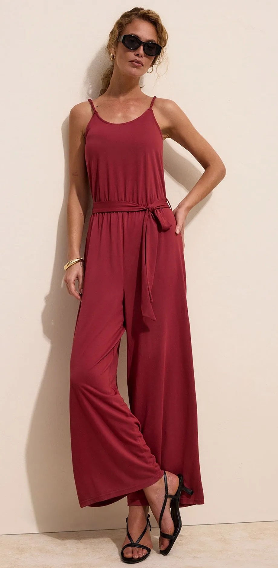 Tuta color vino con spalline sottili e cintura da annodare.