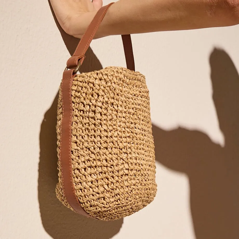 Borsa intrecciata con dettagli in pelle.