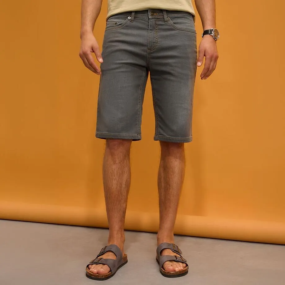 Pantaloncini grigi, maglietta chiara e comodi sandali.