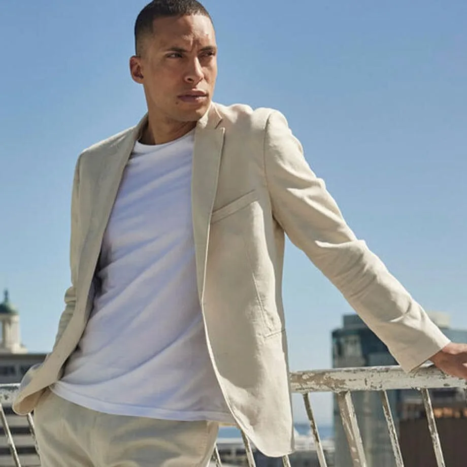 Blazer di lino chiaro con pantaloni coordinati e T-shirt bianca.