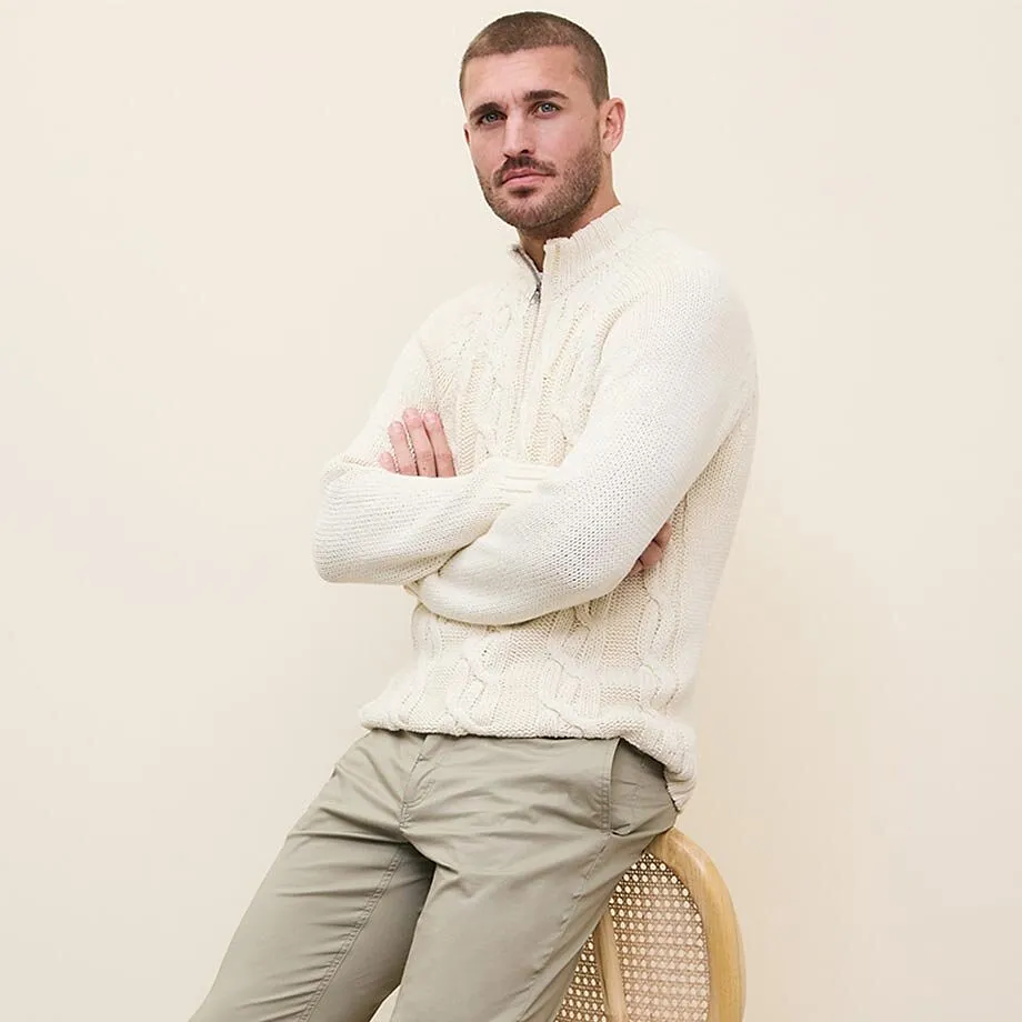 Elegante maglione bianco lavorato a maglia abbinato a pantaloni chino beige.