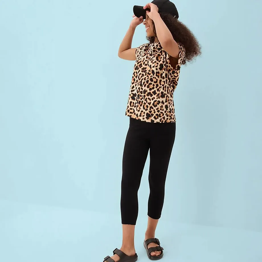 Leggings capri neri e sandali scuri.