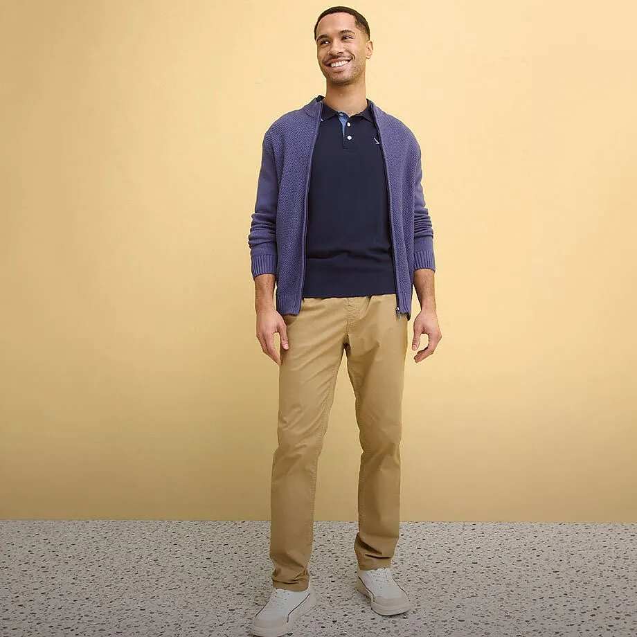 Cardigan viola, polo blu scuro, pantaloni chino beige, scarpe bianche.