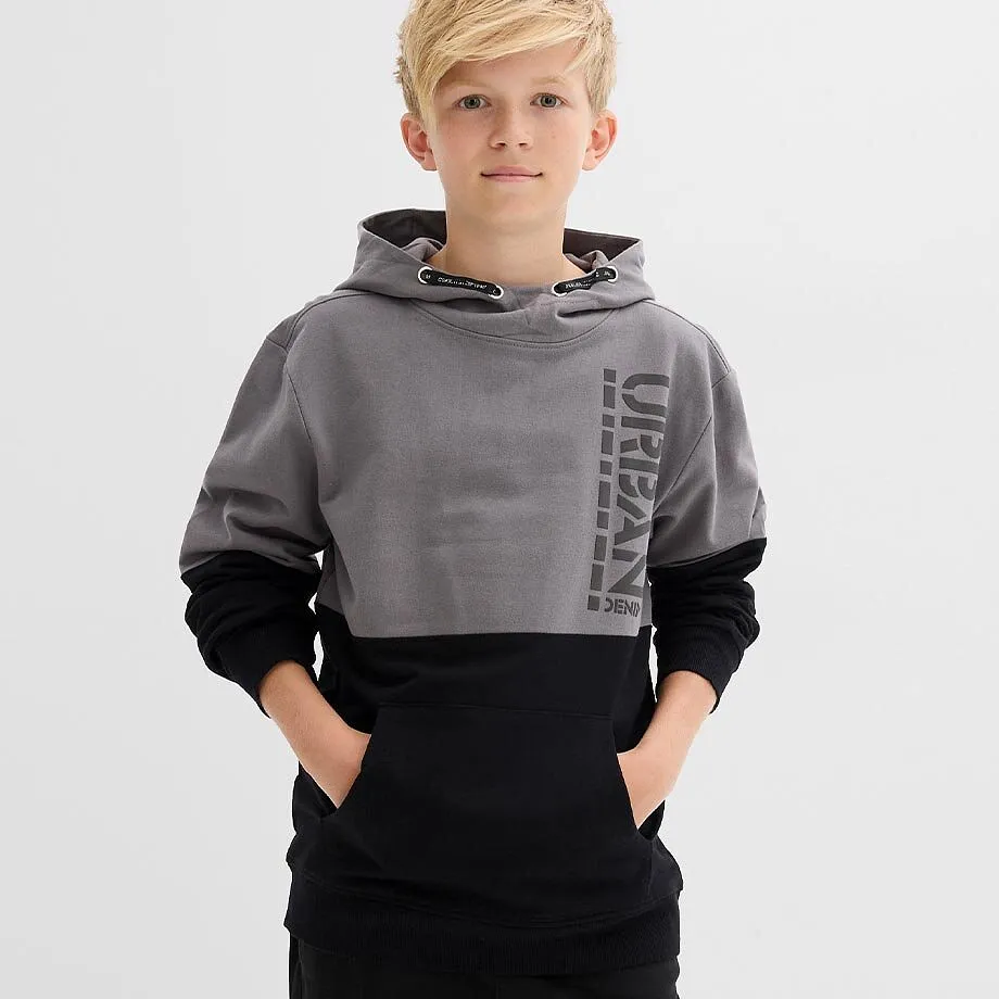 Felpa con cappuccio bicolore in grigio e nero con la scritta &ldquo;URBAN&rdquo;, abbinata a pantaloni neri.