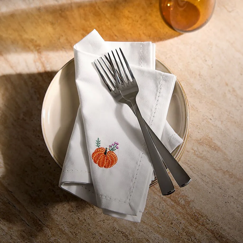 Tovagliolo di stoffa bianco con ricamo a forma di zucca.