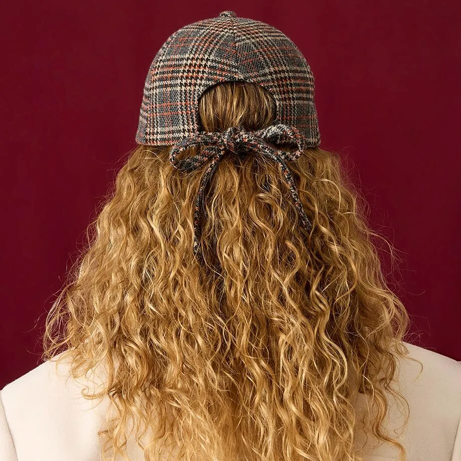 Cappellino a quadri e cappotto color crema per un look elegante.