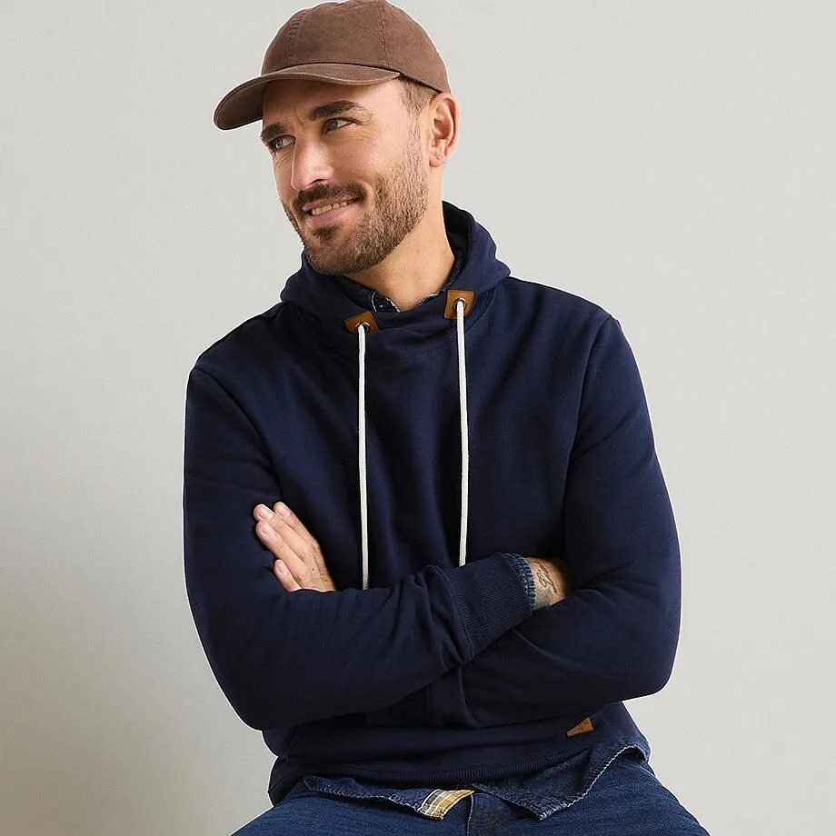 Felpa con cappuccio blu scuro, berretto marrone e jeans per un look casual.