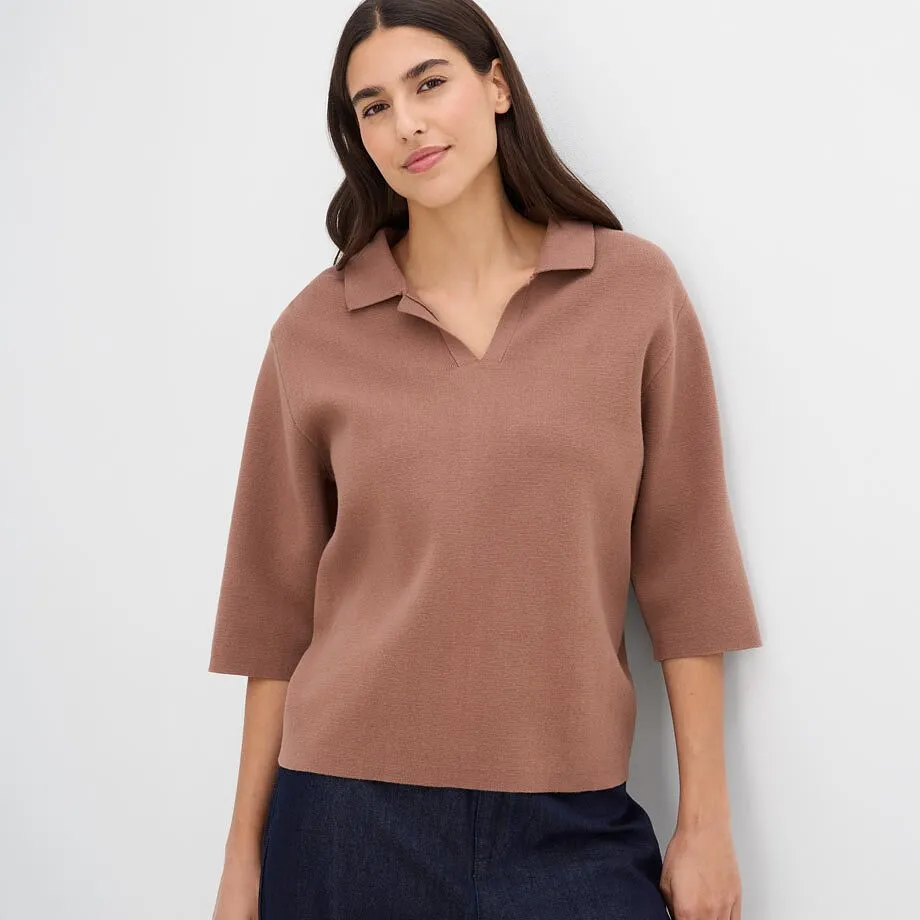 Polo alla moda in maglia marrone con maniche a tre quarti e gonna scura.