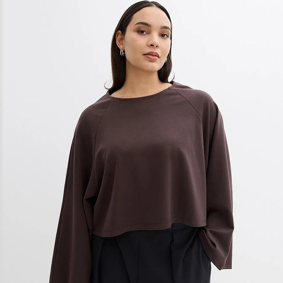 Maglietta a maniche lunghe marrone scuro con maniche larghe e un elegante paio di pantaloni neri.