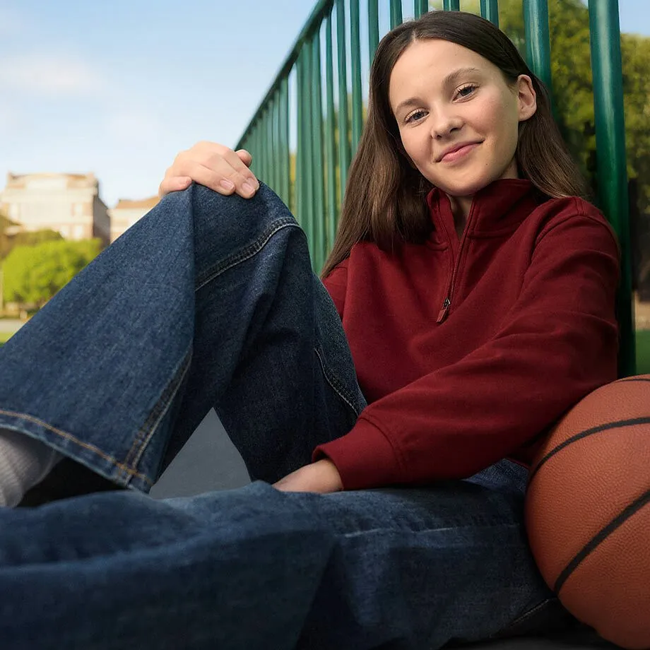 Look casual con maglione rosso e jeans blu.
