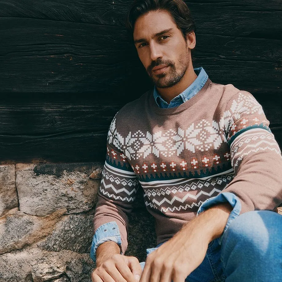 Maglione norvegese con motivo a fiocchi di neve sopra una camicia di jeans e jeans.